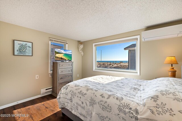 5909 Ocean Blvd, Long Beach Twp, NJ 08008 - bedroom featuring a baseboard heating unit, a textured ceiling, a wall unit AC, baseboards, and dark wood-style flooring