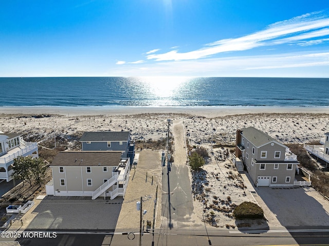 drone / aerial view featuring a beach view and a water view