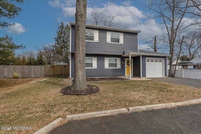 view of front of property featuring a front yard, an attached garage, fence, and driveway