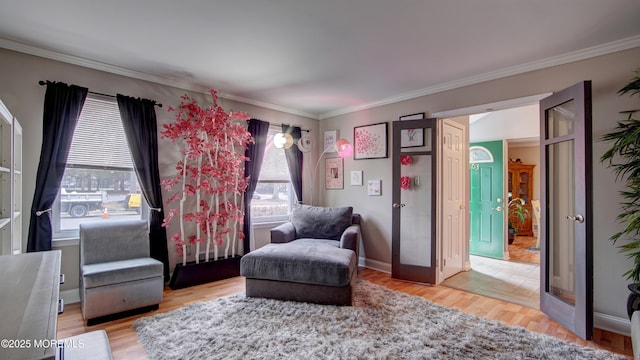 sitting room with ornamental molding, wood finished floors, and baseboards