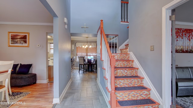 stairs featuring arched walkways, parquet floors, a notable chandelier, ornamental molding, and baseboards