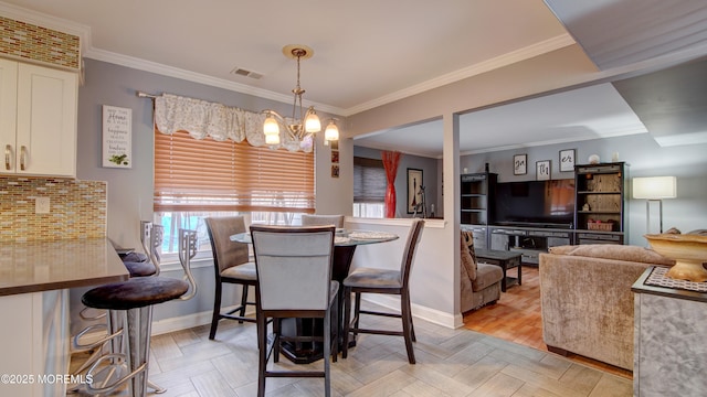 dining area with crown molding, visible vents, and a notable chandelier