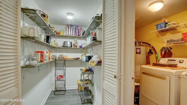 laundry room featuring laundry area, wood finished floors, gas water heater, and washing machine and clothes dryer