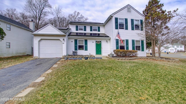 traditional-style house with a front lawn, driveway, and an attached garage