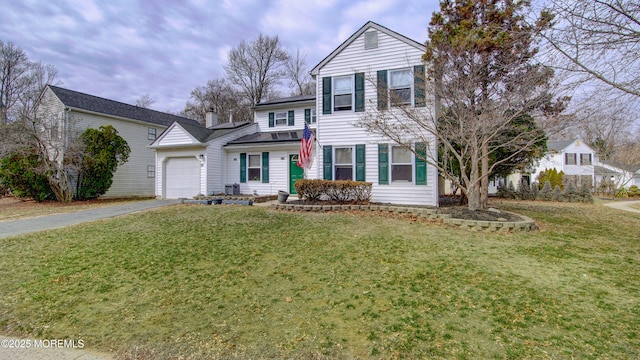 traditional-style home with driveway, a garage, a chimney, and a front lawn