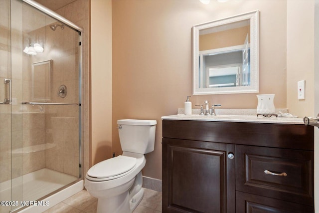 bathroom featuring toilet, vanity, baseboards, tile patterned floors, and a stall shower