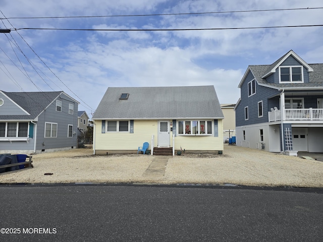 view of front of property with entry steps and a shingled roof