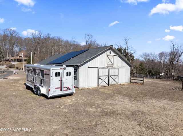 view of barn featuring fence