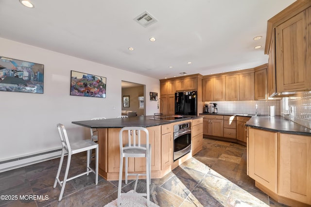 kitchen with tasteful backsplash, visible vents, dark countertops, black appliances, and a kitchen bar