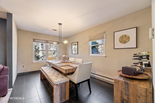 dining space featuring a baseboard radiator, visible vents, baseboards, and dark tile patterned flooring