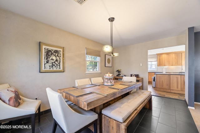 dining room featuring dark tile patterned floors and baseboards