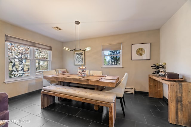 dining space featuring a wealth of natural light, visible vents, dark tile patterned floors, and baseboard heating