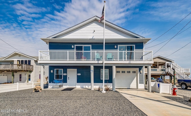 view of front of house featuring driveway, an attached garage, and fence