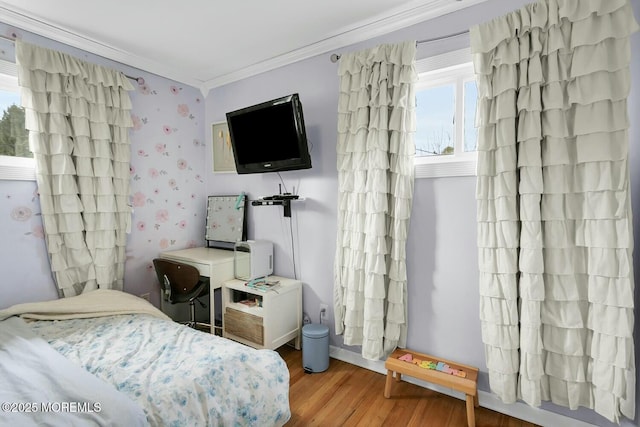 bedroom with wallpapered walls, crown molding, and wood finished floors