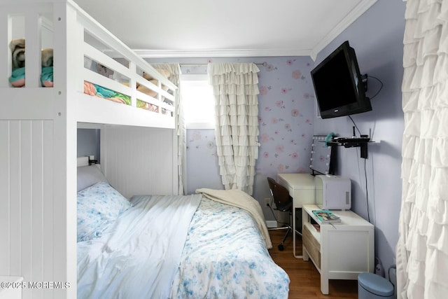 bedroom with ornamental molding, wallpapered walls, and wood finished floors