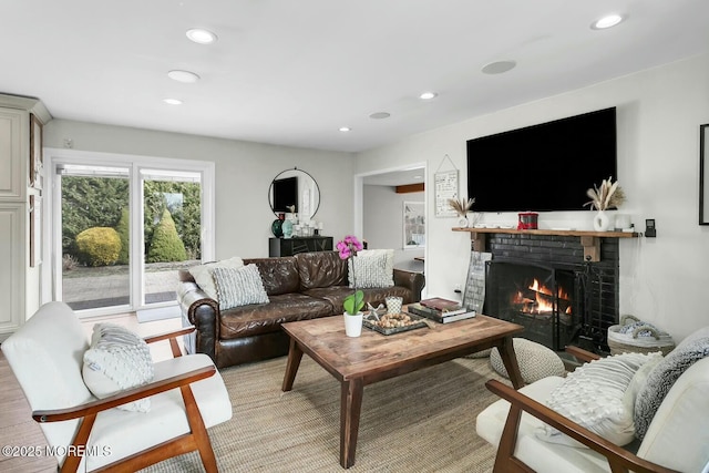 living area featuring recessed lighting and a brick fireplace