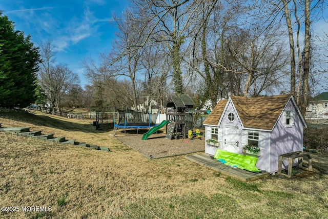 view of yard with an outbuilding, fence, a shed, a playground, and a trampoline