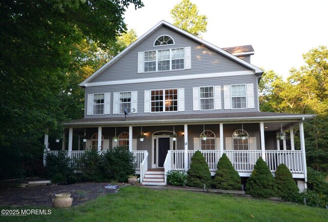 farmhouse inspired home featuring a porch and a front lawn