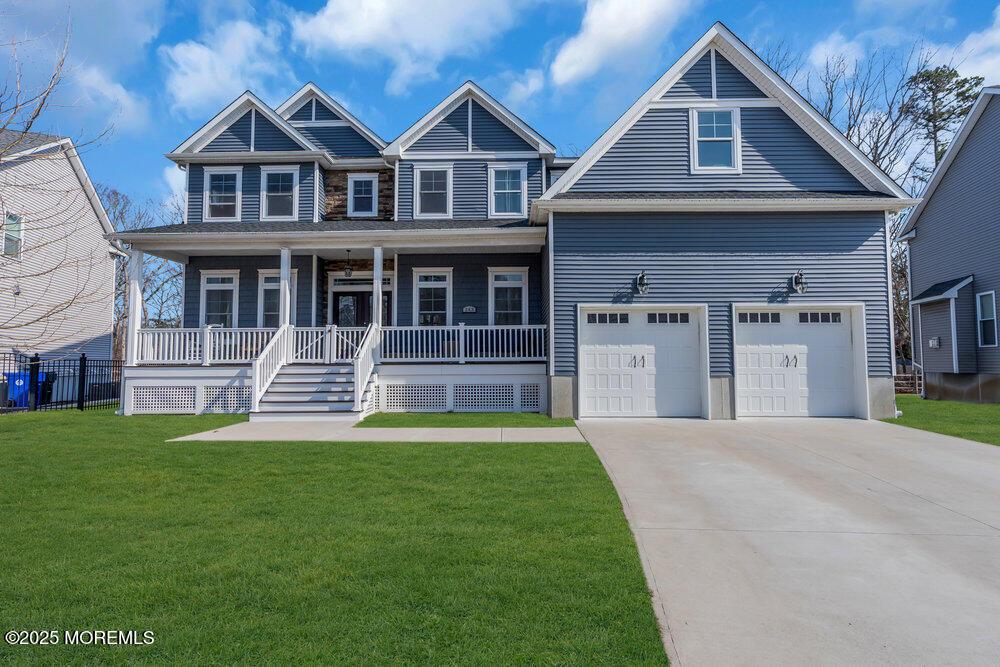 view of front of property with driveway, a front lawn, and covered porch