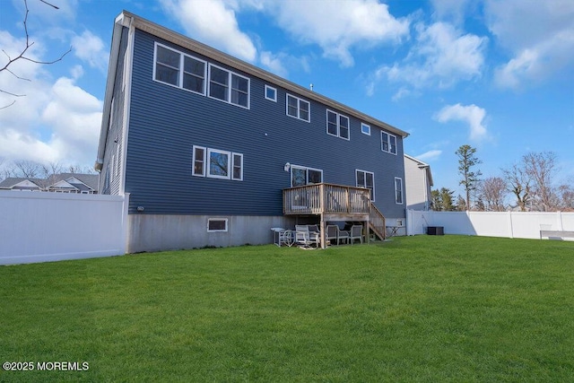 rear view of house featuring a deck, central AC unit, a lawn, and fence