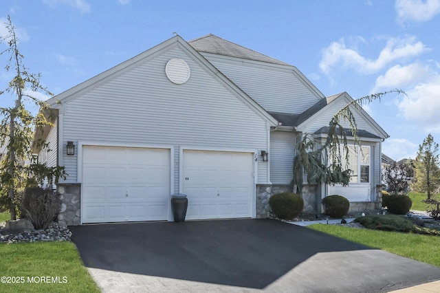 view of front of home featuring a garage, stone siding, roof with shingles, and driveway