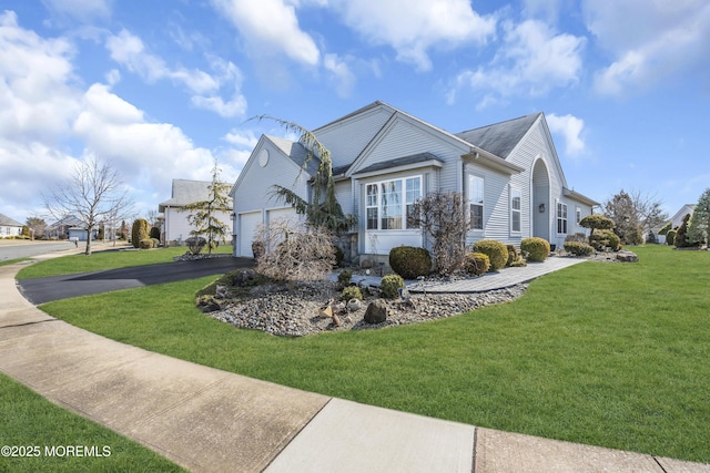 view of side of home with driveway, a garage, and a lawn