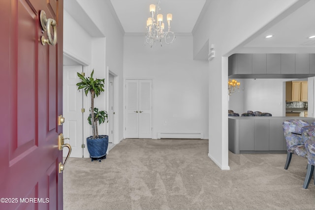 entryway featuring crown molding, carpet floors, baseboard heating, and an inviting chandelier