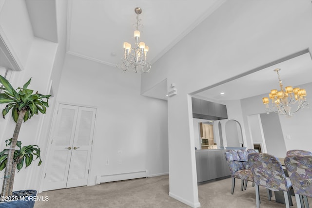 dining area with a chandelier, carpet flooring, and baseboard heating