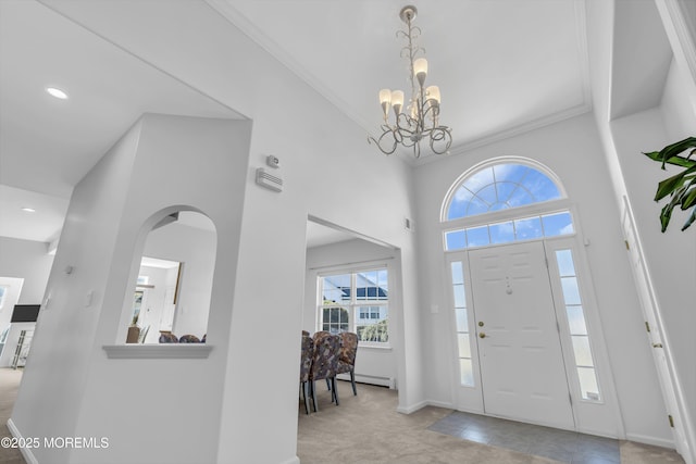 foyer featuring baseboards, an inviting chandelier, and crown molding