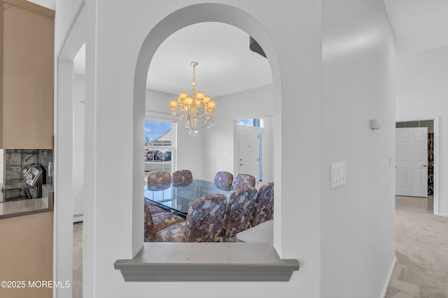 interior space with arched walkways, a baseboard radiator, carpet floors, baseboards, and an inviting chandelier