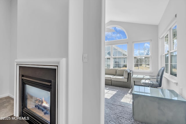 interior details with carpet floors, a multi sided fireplace, and baseboards