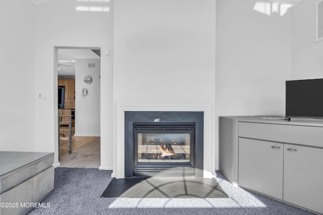 unfurnished living room featuring carpet and a glass covered fireplace