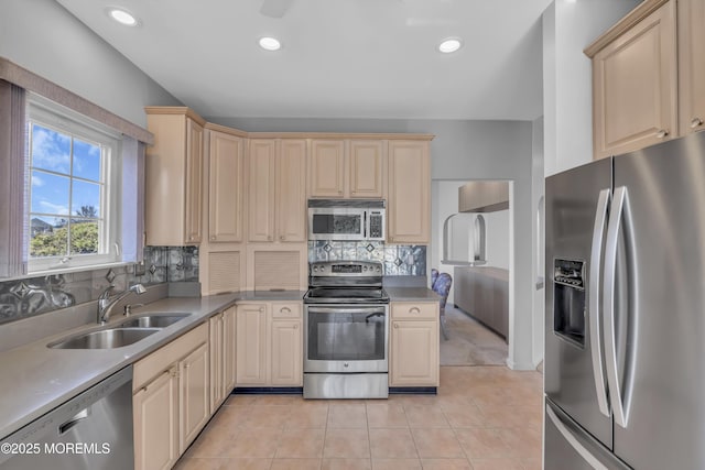 kitchen with recessed lighting, decorative backsplash, appliances with stainless steel finishes, light tile patterned flooring, and a sink