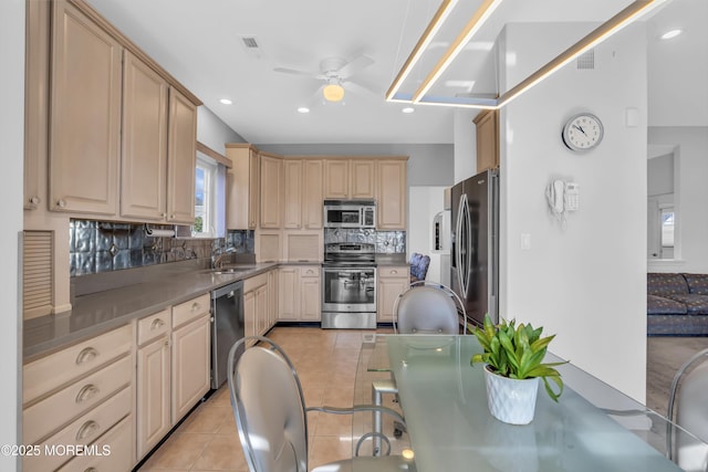 kitchen featuring light tile patterned floors, stainless steel appliances, a sink, visible vents, and tasteful backsplash