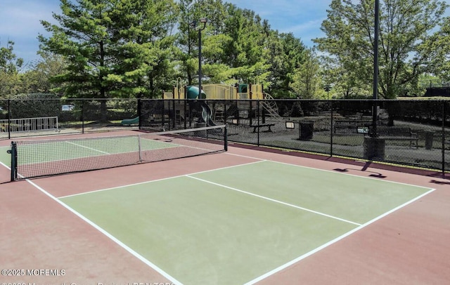 view of tennis court with community basketball court, fence, and playground community