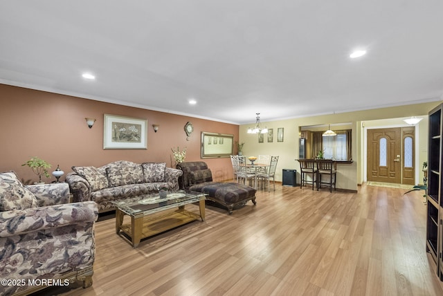 living room with ornamental molding, light wood-style flooring, and recessed lighting