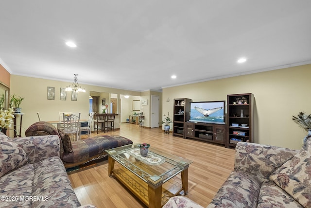 living room featuring crown molding, recessed lighting, a notable chandelier, and wood finished floors