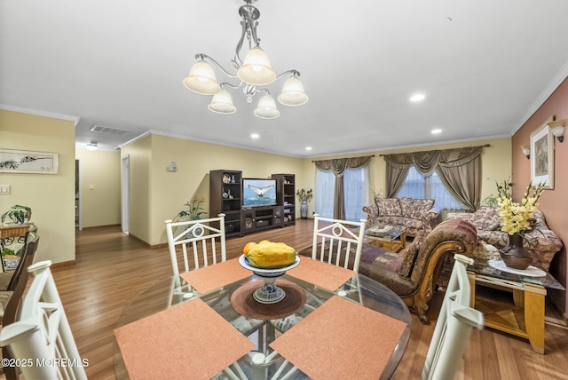 dining space with crown molding, visible vents, baseboards, and wood finished floors