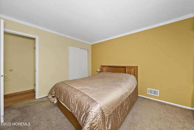 bedroom with baseboards, visible vents, crown molding, carpet floors, and a closet