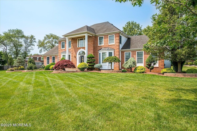 1 Christie Ln, Freehold, NJ 07728 - colonial house with brick siding, a front yard, and a shingled roof