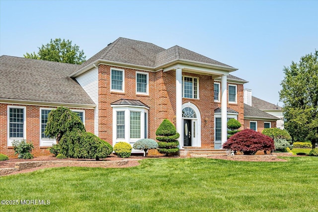 1 Christie Ln, Freehold, NJ 07728 - colonial-style house featuring a front lawn, brick siding, and a shingled roof
