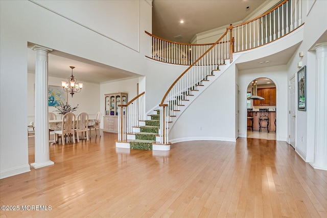 1 Christie Ln, Freehold, NJ 07728 - foyer entrance featuring a high ceiling, stairs, arched walkways, a chandelier, and light wood finished floors
