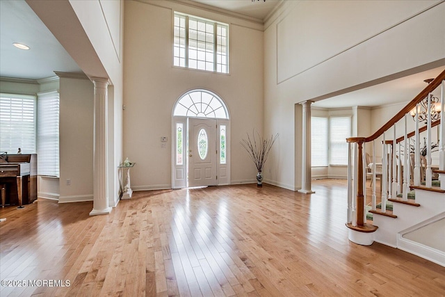 1 Christie Ln, Freehold, NJ 07728 - entrance foyer with ornate columns, crown molding, plenty of natural light, light wood-style flooring, and stairway