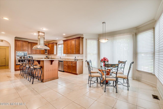 1 Christie Ln, Freehold, NJ 07728 - kitchen with island range hood, stainless steel appliances, brown cabinetry, a kitchen bar, and arched walkways