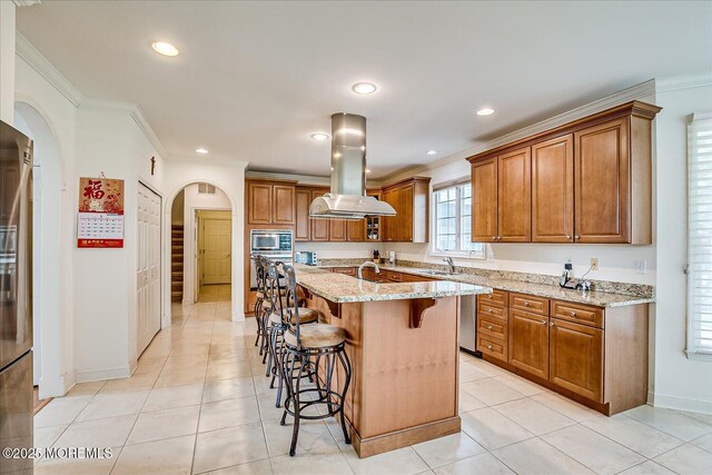 1 Christie Ln, Freehold, NJ 07728 - kitchen with island range hood, appliances with stainless steel finishes, brown cabinetry, arched walkways, and a kitchen bar
