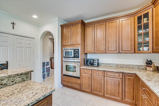 1 Christie Ln, Freehold, NJ 07728 - kitchen with stainless steel appliances, light tile patterned flooring, brown cabinets, crown molding, and arched walkways