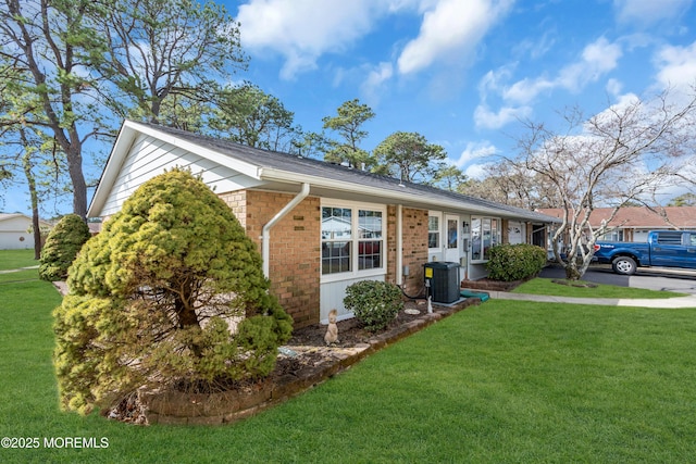 single story home featuring a front lawn, central AC, and brick siding