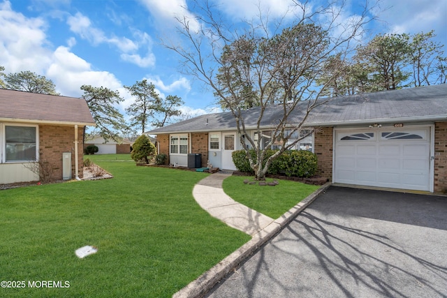 ranch-style house featuring driveway, a garage, a front lawn, and brick siding