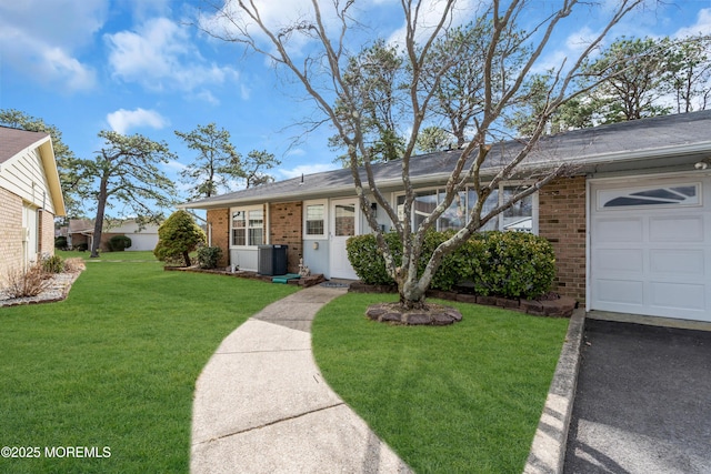 single story home with a garage, brick siding, central AC unit, and a front yard