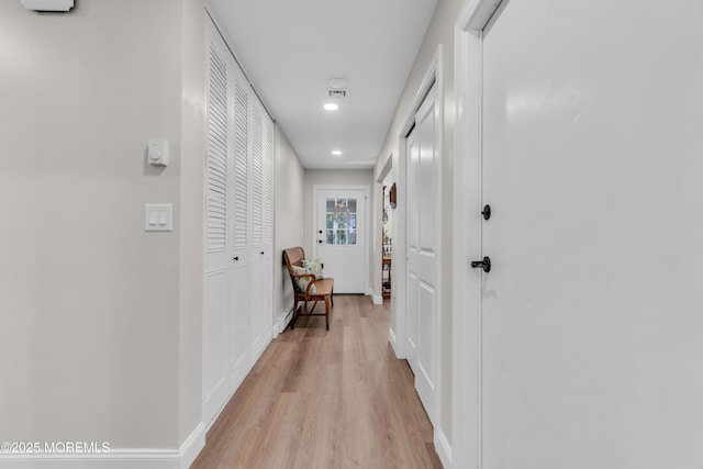 hallway with light wood finished floors and baseboards